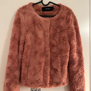 Korallrosa teddyjacka från Vero Moda - Jättefin korallrosa teddyjacka från Vero Moda i storlek S. Jackan har en fluffig textur och öppna fickor. Bara använd ett fåtal gånger och är i mycket bra skick.