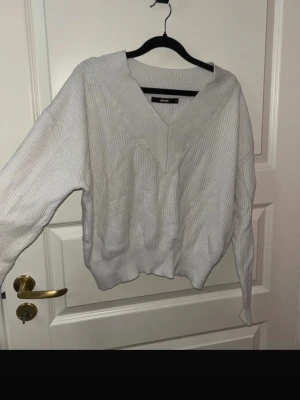 Vit ribbad stickad tröja Bik Bok - Säljer en vit stickad tröja från Bik Bok i storlek S. Tröjan har bred v-ringning, ribbad struktur och lång ärm. Perfekt till lager på lager och har en lite loose passform för en chill vibe.