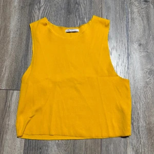 Gul ribbad linnetopp från Zara - Snygg gul ribbad linnetopp från Zara Trafaluc. Toppen är ärmlös med rund halsringning och har en enkel, rak passform. Perfekt att styla till jeans eller kjol för en färgklick i garderoben.