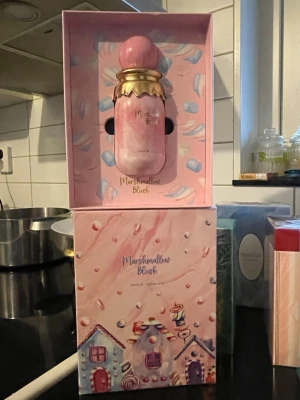 Marshmallow Blush parfym - Söt och lekfull parfym i en unik rosa förpackning med godis-inspirerad design. Perfekt för dig som vill sticka ut och addera en rolig touch till din doftsamling. Volym och ingredienser framgår ej.