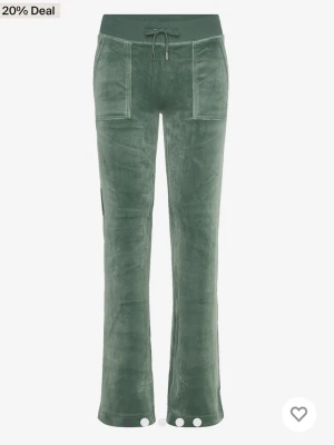 Gröna mjukisbyxor i sammet - Snygga gröna mjukisbyxor i mjuk sammet med bootcut-snitt och bred resår i midjan. Byxorna har snörning och stora fickor framtill, perfekta för en chill och trendig look. !!Köparen står för frakten!!