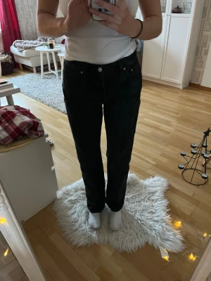 Levi's 505 svarta jeans - Svarta Levi's 505 jeans med klassisk femficksdesign och brunt läderpatch bak. Jeansen är raka i modellen och har en cool, mörk tvätt. Tillverkade i slitstark bomull och har Levi's Premium-märkning på insidan. 