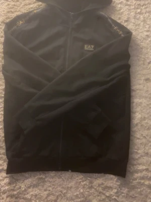 EA7 - Säljer den här hoodien eftersom den är för stor för mig. Köpt på mall of Scandinavia så den är helt äkta. Om du har några frågor skriv privat och kom med prisförslag. Den är L men känns mer som M.