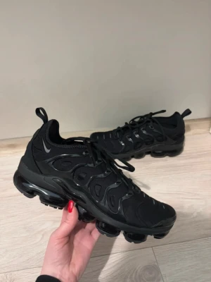 Svarta Nike Air Vapormax sneakers - Säljer ett par helsvarta Nike Air Vapormax sneakers med cool, futuristisk design och synlig luftdämpning i skorna. Skorna är i nyskick och såklart är de äkta. Skorna är storlek 43 men passar även 42 utmärkt. Hör av er vid frågor