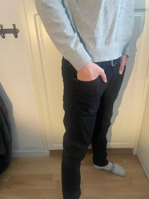 Tiger of Sweden Jeans - Snygga svarta byxor från Tiger of Sweden med klassisk femficksdesign. Byxorna har en rak passform och är tillverkade i ett mjukt bomullsmaterial med lite stretch. Perfekta för dig som gillar stilrena och enkla plagg.