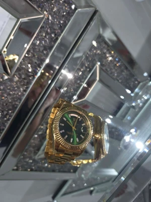 Ingen—detta är en klocka, inte en väst - Bilderna visar feet en guldfärgad klocka med grön urtavla och länkarmband, men ingen väst finns på bilderna.