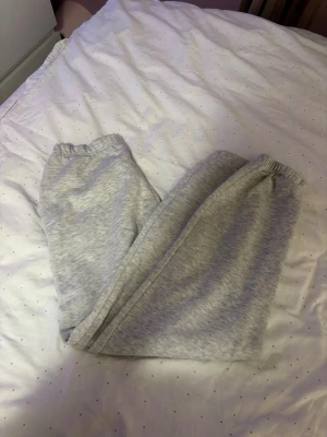 Grå mjukisbyxor från Gina tricot SX - Ljusgrå mjukisbyxor från Giantifoot i storlek SX. Byxorna har resår i midjan och är tillverkade i mjukt bomullsmaterial, perfekta för chill dagar hemma eller när du vill vara extra bekväm.