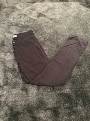 NN07 Chinos - Säljer ett par stilrena mörkblå chinos från NN07, modell Marco 1400. Även kallat No Nationality. Byxorna har klassisk rak passform, sidofickor och är tillverkade i mjukt bomullsmaterial. Perfekta för dig som gillar en clean och enkel look. I storlek 28/32 för dam.