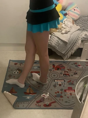 Thuono konståkningskjol - Kort kjol från Thuono i svart och turkos med volang och glittrig logga. Kjolen har bred resår i midjan och dubbla lager. Passar allt från ca 152-XS (väldigt stretchig). Pris kan diskuteras🥰