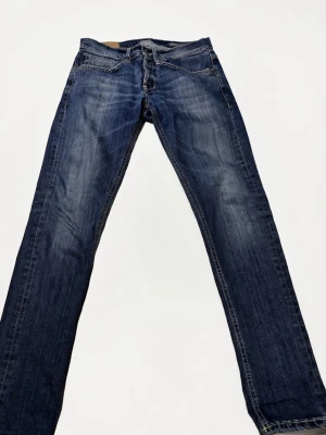 Dondup Jeans George - Dondup jeans i mörkblå tvätt med raka ben och fem fickor. Jeansen har en snygg slitning framtill och är bra för dig som vill uppnå en stilig look