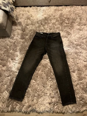 Svarta loose fit jeans Jack & Jones - Säljer ett par svarta loose fit jeans från Jack & Jones, modell Loose/Chris. Jeansen har klassisk femficksdesign, raka ben och är tillverkade i slitstark denim. Perfekta för dig som gillar en avslappnad och trendig look. Mycket bra skick. Använd någon enstaka gång.