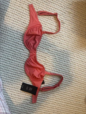 koral rosa bikini - Säljer denna bikini toppen från nakd som aldrig är använd med lappen kvar! Skulle säga att den är något liten i storlek