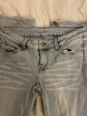 Cheap Monday ljusblå jeans med tryck - Säljer ett par ljusblå jeans från Cheap Monday med coolt tryck på bakfickan. Anledningen till att jag säljer dom är att dom krympt lite 