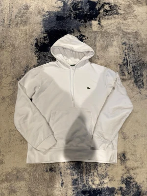 Vit Lacoste hoodie - Bra skick. Storlek L men sitter som M/S. Kvitto från Zalando finns. Pris kan diskuteras vid snabb affär 