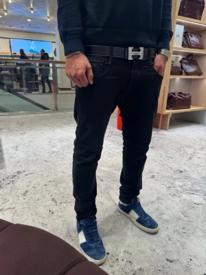 Svart H bälte med H - spänne - Snyggt H bälte som kommer helt nytt och inplastat. Storlek 105 cm. Inga konstigheter tveka ej på att höra av dig vid funderingar. 