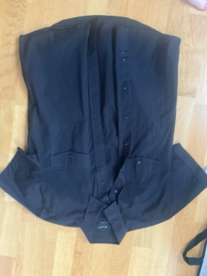 Svart skjorta Tiger of Sweden - Klassisk svart skjorta från Tiger of Sweden i storlek 41. Skjortan har två bröstfickor med knappar och en stilren krage. Tillverkad i mjuk bomull som känns skön mot huden. Perfekt för dig som gillar en clean och tidlös look.