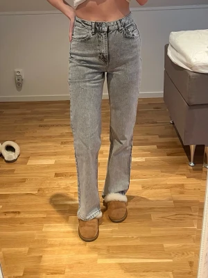 Gråa jeans från NA-KD - Säljer ett par ljusgrå raka jeans från NA-KD i storlek 34. Jeansen har hög midja.  Snygg tvättad look som passar br si alla överdelar🩶🩶 