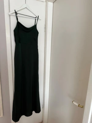 Mörkgrön långklänning med tunna band - Säljer min balklänning jag hade på 9:ans bal, den är mörkgrön och är öppen i ryggen. Banden går att justera. Skriv för mer bilder
