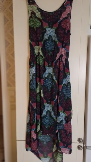 Mönstrad långklänning i flera färger - Unik långklänning med färgstarkt blommigt mönster i blått, grönt, vinrött och rosa. Klänningen har ärmlös design och rundad halsringning. Tillverkad i ett lätt och luftigt material, perfekt för varma dagar. H&M