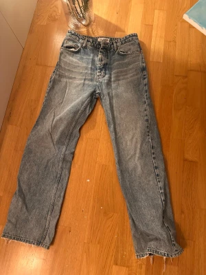 Blå straight jeans från Just Junkies - Säljer ett par ljusblå jeans från Just Junkies med klassisk femficksdesign och råa kanter vid bensluten. Jeansen har en rak passform och är tillverkade i slitstarkt denimtyg. Perfekta för en avslappnad och trendig look.