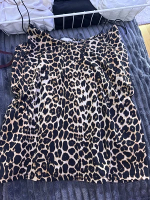 Leopardmönstrad linnetopp med smala band - Säljer en snygg leopardmönstrad linnetopp med tunna axelband. Toppen har en loose passform och är i beige och svart med coolt djurmönster. Perfekt för dig som vill sticka ut och addera lite edge till din outfit.