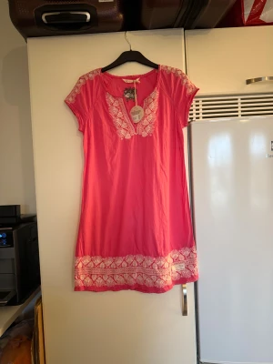 Odd Molly Icecream Dress Sorbet Rose - Supersöt kort klänning men jag tycker den mer är en längre topp från Odd Molly i färgen sorbet rose. Modellen har broderade detaljer i vitt längs halsringning, axlar och nederkant. Mjuk bomullskvalitet och kortärmad design med avslappnad passform. Storlek 3 som enligt deras storleksguide motsvarar en L. Men är liten i storlek. Helt ny med tags/ prislapp fortfarande kvar. 