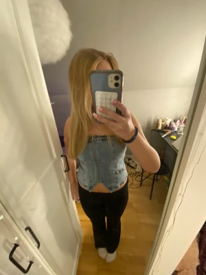Ljusblå denim tubtopp - Säljer en ljusblå tubtopp i denim. Typ som en korsett. 🤩Toppen är axelbandslös och har en snygg, croppad passform som sitter tight mot kroppen. Perfekt som festtopp😍