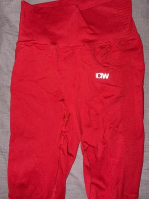 Röda seamless tights från ICANIWILL XS - Säljer ett par röda seamless tights från ICANIWILL i storlek XS. De har hög midja, ribbade detaljer i midjan och meshpaneler längs benen för extra ventilation. Perfekta för träning och riktigt snygga på gymmet.