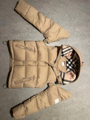 Burberry pufferjacka - Kostar 11000 SEK ny. Fick den i födelsedagspresent, var köpt för 7500 på rea i November 2025. Säljer den för jag inte tycker om den och är inte min stil. Ända defekten är hängöglan som är trasig. Träffas gärna i verkligheten eftersom det finns mycket bedrägare här ute. Kan mötas i Skellefteå eller Luleå🙂Bara att skriva om fler bilder eller funderingar!