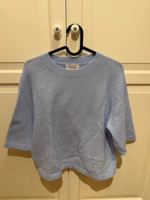 Ljusblå stickad tröja &Other Stories - Ljusblå stickad tröja från & Other Stories med rund hals och trekvartsärm. Använts ett fåtal gånger. 