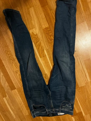 Replay Anbass mörkblå jeans - Mörkblå jeans från Replay, modell Anbass. Klassisk femficksdesign med snygga detaljer på bakfickorna och smal passform. Jeansen är tillverkade i stretchig denim för extra komfort och har en stilren look som funkar till det mesta. Inga deffekter, diskuterar pris 🏆 