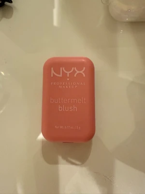 NYX Buttermelt Blush Soft Pink - Oöppnad! NYX Buttermelt Blush i färgen 02 Butta Together, en mjuk puderrouge i nyansen soft pink. Kommer i en söt, kompakt rosa dosa på 5g. Ger kinderna en fräsch och naturlig rosa ton med silkeslen finish. Perfekt för att skapa en fräsch look.