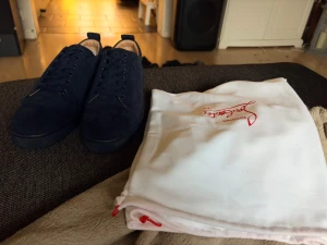 Mörkblå mockasneakers från Louboutin - Säljer ett par riktigt snygga mörkblå sneakers från Christian Louboutin i mocka. Skorna har klassisk snörning och den ikoniska röda sulan med Louboutin-loggan. Perfekta för dig som vill sticka ut med exklusiv stil.