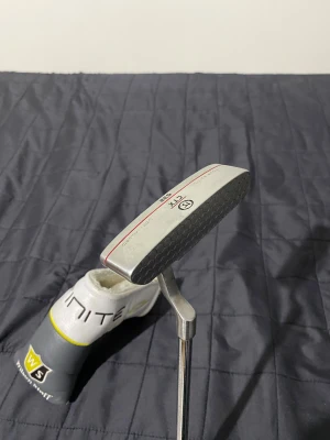 CTX Blade putter 632 Coin Milled Tour edition - Säljer CTX Blade putter tour edition, en elegant och exakt putter för tour inspirerade kontroll och känsla. Den är en klassiskt Blade design med en coin milled face som ger en mjuk, konsekvent rull och förbättrad bollkontroll. Med sin kompakt profil och justerbart viktning levererar den en stabil och förtroendeingivande sving vikt.    Stål skaft  högerhänt  Grep CTX standard  Inkluderar en Wilson Staff infinite headcover.  Hämtas vid Knivsta Station, eller skickas mot frakt.Köparen betalar kostn