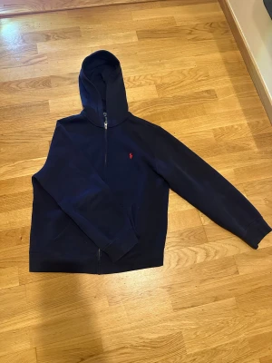 Polo Ralph Lauren hoodie  - Hej jag säljer en mörkblå Polo Ralph Lauren hoodie. Jag är osäker på storleken eftersom det är i barn. Men jag skulle säga att den passar om man är 160cm och lite mer åt det breda hållet och om man är 170cm och är lite smalare.