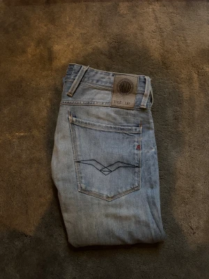 Ljusblå jeans med broderade bakfickor - Säljer ett par ljusblå jeans från Replay med snyggt broderade bakfickor och klassisk läderpatch i midjan. De är lite stora på mig och därför det ser lite pösiga ut men passar perfekt på någon lite större! Jeansen har en rak passform och en allmänt skön del till en outfit! Ifall du har några funderingar är det endast att höra av sig!🍾🥂