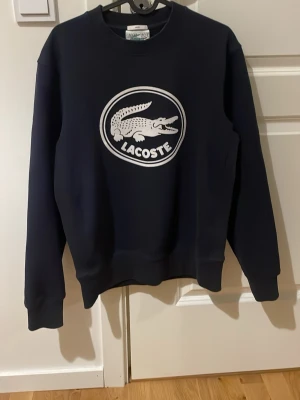 Lacoste tröja - Säljer den här fina mörkblåa Lacoste tröjan eftersom den har blivit för liten, har haft den sen augusti så fortfarande jätte bra skick