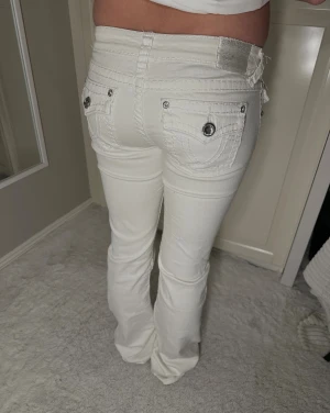 Vita bootcut jeans med strass - Snygga lågmidjade jeans från L.A Idol USA med diamant strassdetaljer, passar långa personer men går även klippa upp de☺️💗                  Midjemått: 74cm            Innerbenslängd: 85cm