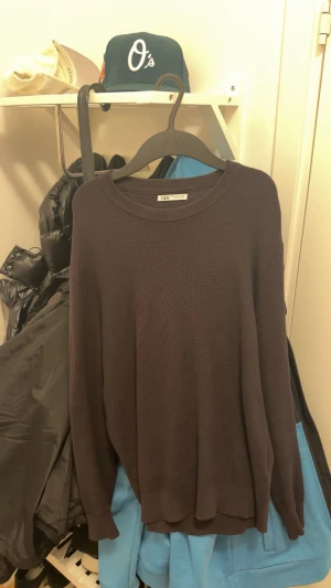 Stickad tröja från Zara - Säljer en stickad tröja från Zara med rund halsringning och avslappnad passform. Tröjan har lång ärm och är tillverkad i ett mjukt, strukturerat material som passar perfekt för kyligare dagar.