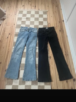 Bootcut jeans XS från 157, blå & svarta - Två par bootcut jeans från 157 i storlek XS . Ett par är ljusblå med broderad detalj på bakfickan och kort längd, det andra paret är svarta med full längd. Båda har klassisk femficksdesign och är tillverkade i jeansmaterial.De blå är i short och de andra full length 