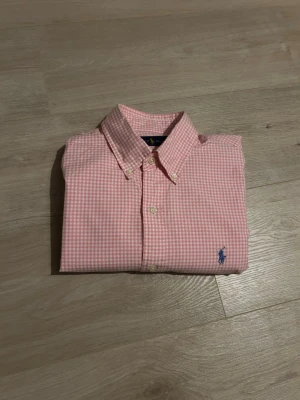 Rosa Rutig Ralph Lauren Skjorta - Klassisk Ralph Lauren skjorta i rosa färg. Tröjan är i mycket bra skick, sparsamt använd. |   Storlek: M | Skick: Mycket bra skick! | Färg: Rosa | Märke: Ralph Lauren | Modell: Skjorta   |  Hör gärna av dig vid frågor så svarar jag så fort jag kan! 😁|  