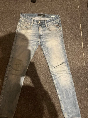 Replay jeans  - Snygga ljusblå skinny jeans från Replay med klassisk femficksdesign och diskreta slitningar. Jeansen har låg midja och är tillverkade i mjuk bomull med en liten mängd stretch för extra komfort. Perfekta för en avslappnad och trendig look.
