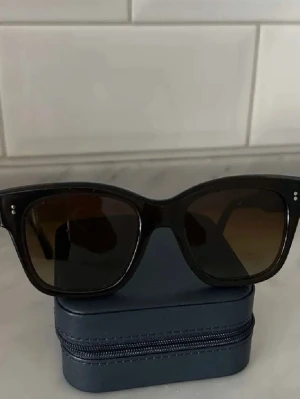 Bruna Chimi solglasögon - Stilrena svarta solglasögon med klassisk  båge och mörka glas. Solglasögonen är från Chimi i den bruna färgen som man ser på första bilden i modellen 07