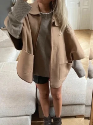 Oversized beige poncho kappa med fickor - superfin cape/kappa/poncho från massimo dutti 🤎 jättebra kvalitet och känns verkligen lyxig. perfekt att slänga över en stickad tröja. oversized fit så funkar på flera storlekar. i väldigt fint skick knapppt använd ✨Väldigt efterfrågad!! 
