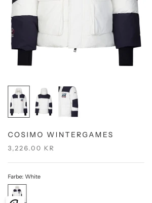 Vit och marinblå pufferjacka från 19V69 - Snygg pufferjacka från 19V69 Italia Cosimo Wintergames i vitt och marinblått. Jackan har stora fickor framtill, broderad patch på bröstet och svarta muddar vid ärmslut. Perfekt för kalla dagar med sin tjocka vaddering och sportiga look. Den är helt ny med storlek M och har alla taggar med