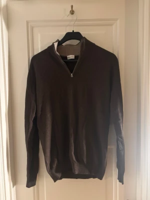 Brun halvzip-tröja John Henric - Snygg brun långärmad tröja från John Henric med halv dragkedja och ribbad krage. Perfekt för lager-på-lager och enkel att matcha med jeans eller annat. Materialet känns mjukt och bekvämt mot huden. Den är stilren och klassisk. Tveka inte att höra av dig vid eventuella frågor eller pris! 