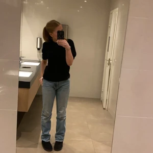 Blå raka jeans från Zara - Säljer ett par blå raka jeans från Zara i storlek 36. Jeansen har en klassisk tvättad look med ljusa slitningar och normal midja. Mid waist skulle jag säga. 