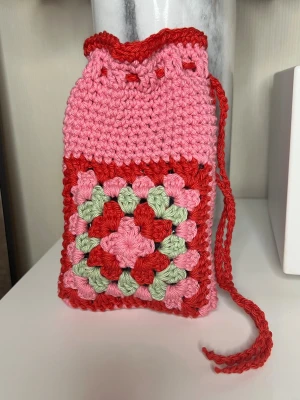 Valentine’s pouch - Virkad påsväska  - Handgjord virkad påsväska i rosa, rött och ljusgrönt bomullsgarn. Virkad av mig. Längd och bredd hittar du bild 3. Exempel på hur du kan använda påsen finns i bilderna 🩶 