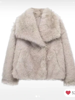 Beige fluffig fuskpälsjacka dressy - Supersnygg beige fuskpälsjacka med bred krage och rak passform. Jackan har en mjuk och fluffig yta som ger en lyxig känsla. Perfekt för att hålla värmen under kalla dagar och ger en trendig look till din outfit. Ny utan prislapp, från dressy 