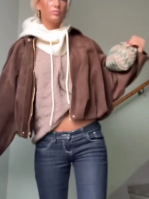 Brun mocka bomberjacka med dragkedja - Aldrig använd, lappen är kvar. Snygg brun bomberjacka i mocka med dragkedja framtill. Jackan har en loose passform och långa ärmar, perfekt för en trendig och avslappnad look. Passar till både jeans och kjol för en cool vardagsstil.